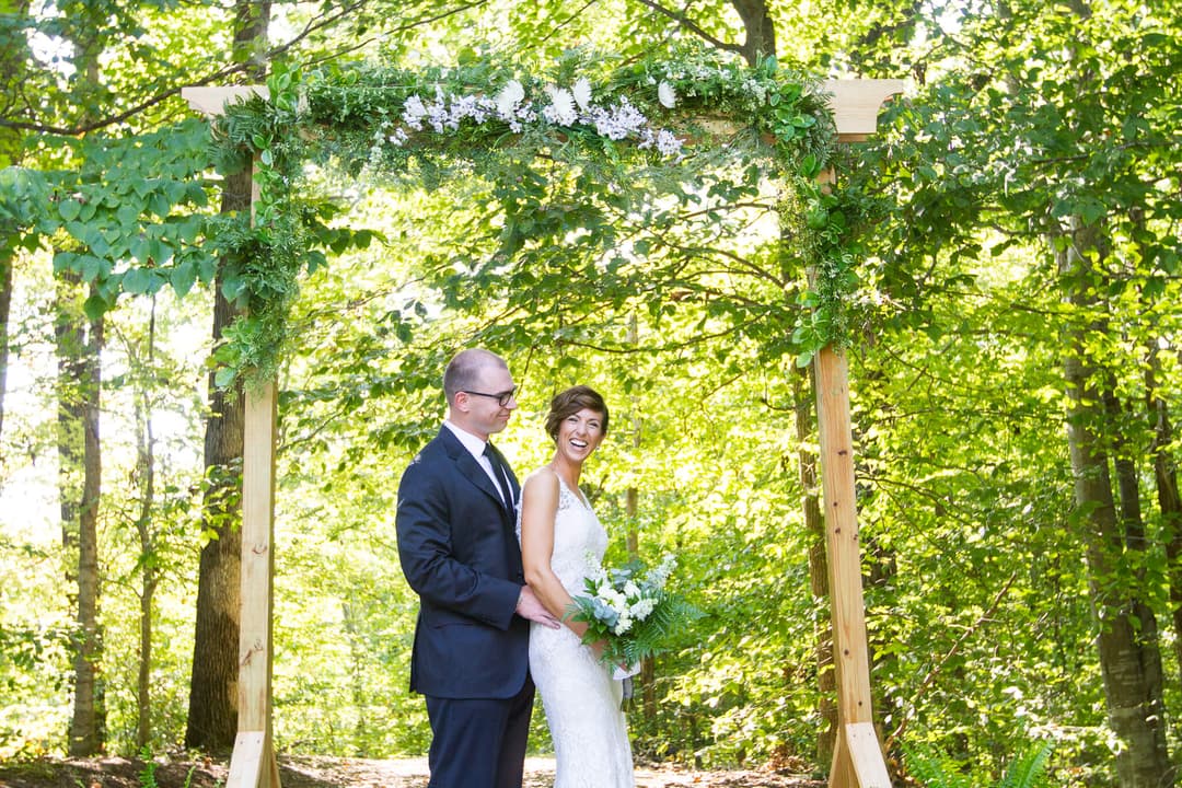 Bride and groom standing in classic prom pose, bride laughing.