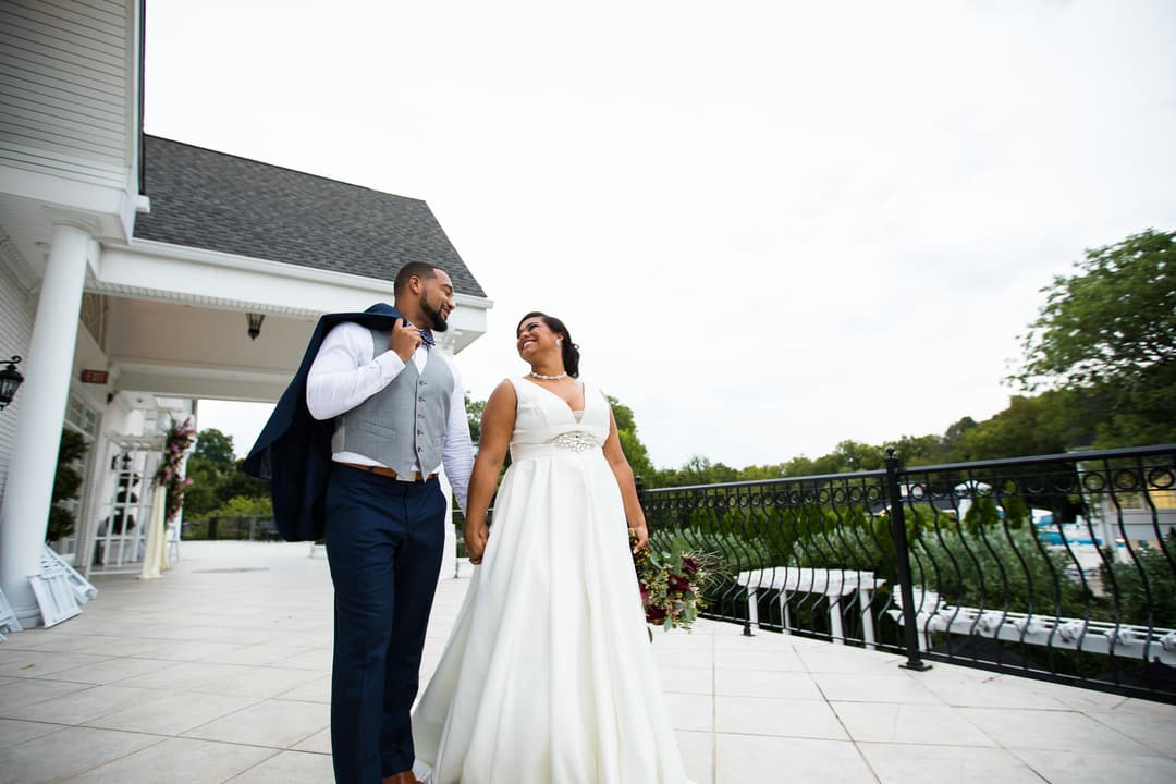 Bride and groom in a close embrace, bride adjusting groom's bow tie.